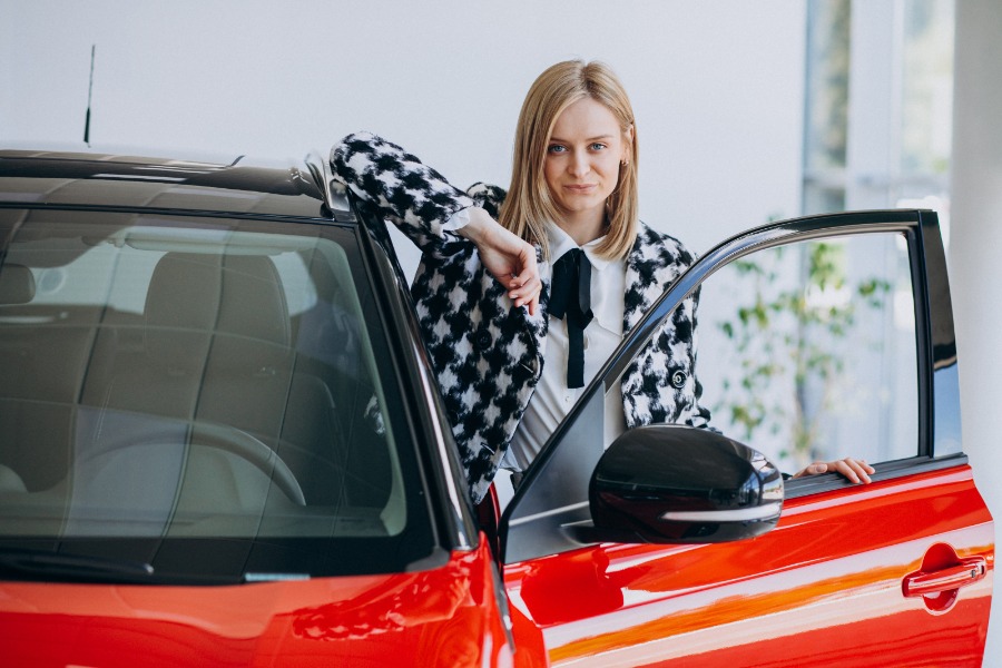 Blonde woman with red car